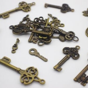 May include: A collection of antique-style keys in a bronze finish. The keys are various sizes and shapes, with intricate details and ornate designs. Some keys have heart-shaped keyholes.