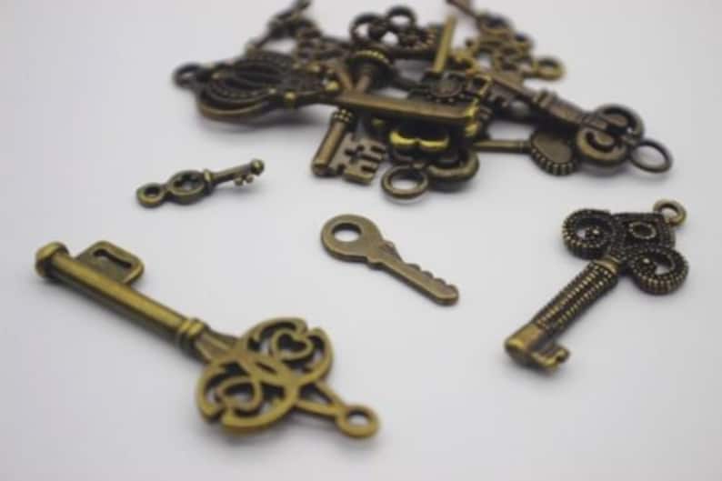May include: A collection of antique-style keys in a bronze finish. The keys are various sizes and shapes, with intricate details and ornate designs.