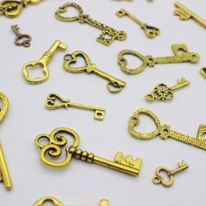 May include: A collection of antique gold-toned skeleton keys with ornate designs. The keys are scattered on a white surface.