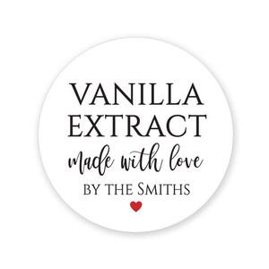 May include: A white, circular label with the words "VANILLA EXTRACT" in a bold, black font. Below, in a cursive font, it reads "made with love" and "BY THE SMITHS". A small red heart is at the bottom.