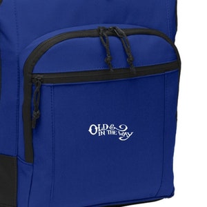 May include: A royal blue backpack with black accents and a white embroidered logo that says "Old & In The Way".
