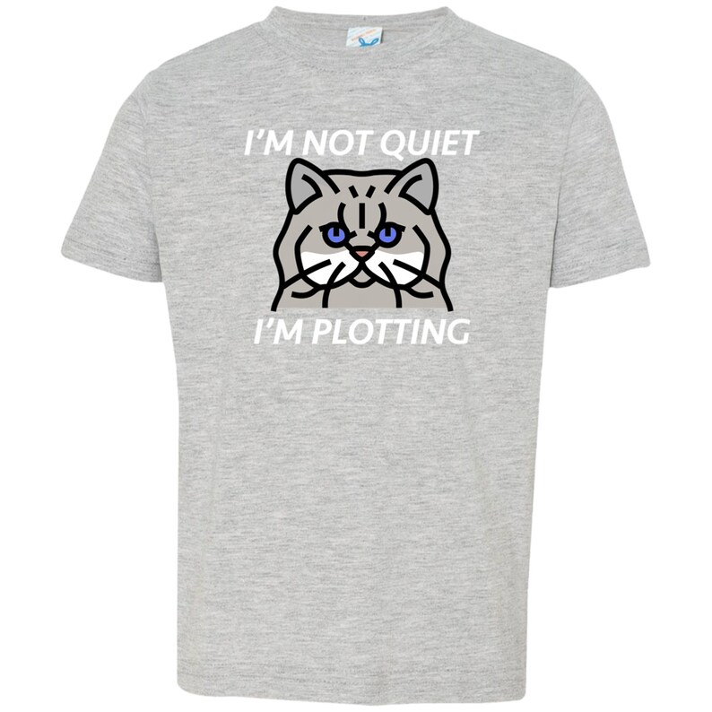 Pode incluir: Uma camiseta cinza com um gr&aacute;fico branco de um gato com olhos azuis e o texto "I'm not quiet I'm plotting".
