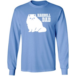 May include: A light blue long-sleeved t-shirt with a white silhouette of a Ragdoll cat and the text "Ragdoll Dad".