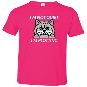 Pode incluir: Camiseta rosa para crian&ccedil;a pequena com um gato de desenho animado e o texto "N&atilde;o estou quieto, estou tramando."
