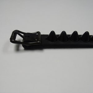 May include: Black leather bracelet with a silver buckle and black pyramid-shaped studs.