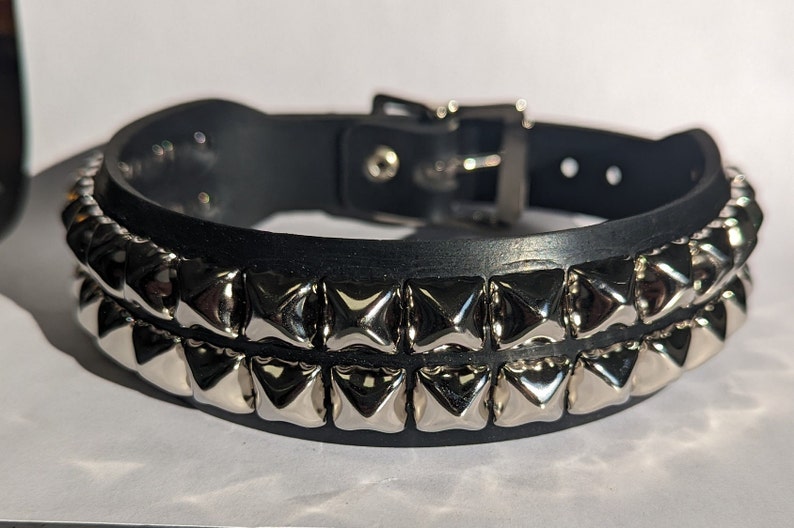 May include: A black leather choker with two rows of silver pyramid-shaped studs.