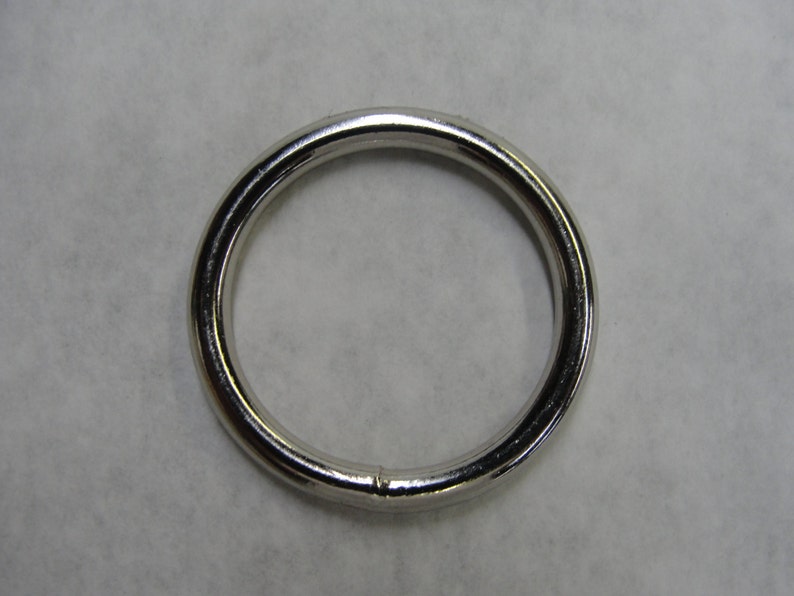 May include: A silver metal ring, also known as a key ring or jump ring, is a simple, circular shape with a smooth, polished finish.
