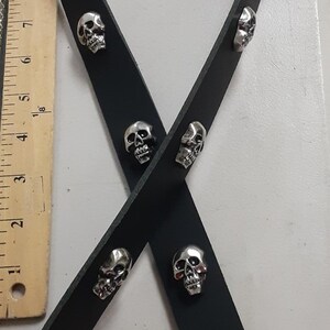 May include: Black leather strap adorned with silver skull studs. The strap features metal clasps and rivets. A ruler is visible in the background. The image is labeled "Similar shots Jan 14, 2022".