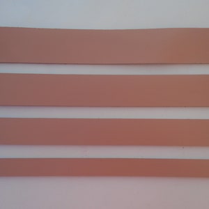 Pode incluir: Quatro tiras horizontais de material marrom claro, espa&ccedil;adas uniformemente, sobre um fundo branco.