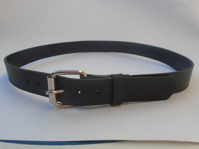 May include: A black leather belt with a silver buckle. The belt is approximately 2.5 cm wide.