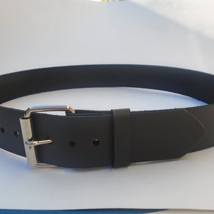 May include: A black leather belt with a silver buckle. The belt is approximately 3.8 cm wide and has a pointed end.