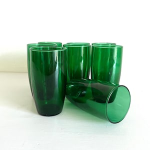 May include: Set of ten green glass tumblers. The glasses are tall and slender with a rounded bottom.