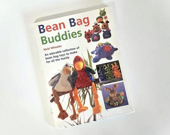 May include: A book titled "Bean Bag Buddies" with colorful illustrations of bean bag toys. The cover features a variety of stuffed animal designs, including a bird, a duck, and a rabbit. The book's subtitle reads "An adorable collection of bean bag toys to make for all the family."