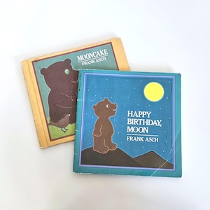 May include: Two children's books with brown bears on the covers. The first book is titled "Mooncake" by Frank Asch. The second book is titled "Happy Birthday, Moon" by Frank Asch.