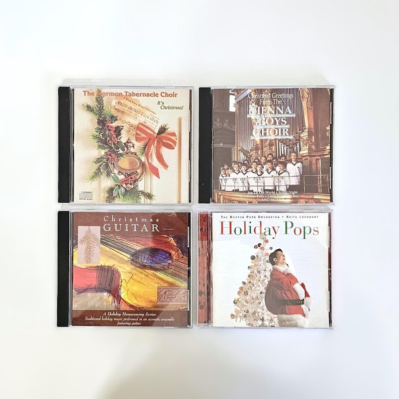 K&ouml;nnte beinhalten: Vier CDs mit Weihnachtsmotiven. Die CDs befinden sich in Jewel Cases mit bunten Illustrationen. Die Titel lauten "The Mormon Tabernacle Choir It's Christmas!" "Christmas Greetings from the Vienna Boys Choir" "Christmas Guitar" und "Holiday Pops The Boston Pops Orchestra Keith Lockhart".
