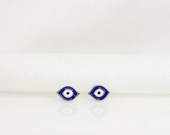 May include: A pair of silver earrings with blue and white enamel evil eye designs.