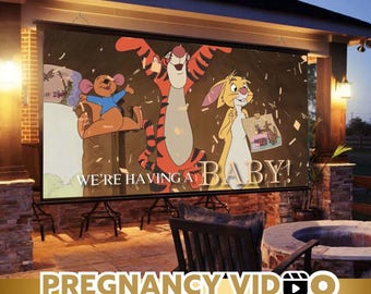 May include: A large outdoor movie screen displays a cartoon image of Winnie the Pooh characters, including Tigger, Roo, and Rabbit, with the text "WE'RE HAVING A BABY!". The screen is set up in a backyard setting with a fire pit and seating.
