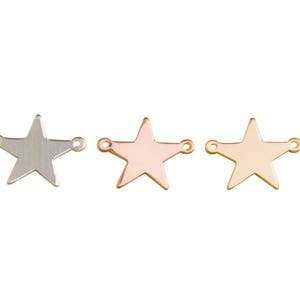 May include: Three metal star charms with jump rings. The stars are silver, rose gold, and gold.