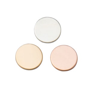 Peut inclure: Trois disques métalliques ronds de différentes couleurs : argent, or et or rose. Les disques sont lisses et brillants.