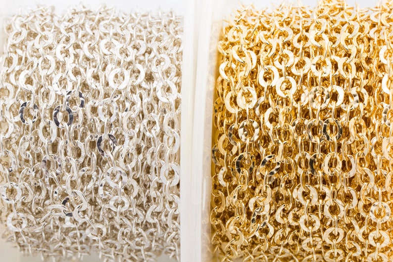 May include: Two spools of chain, one silver and one gold. The chain is a delicate, linked design.