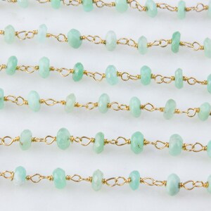 Pode incluir: Uma linha de contas de pedras preciosas verde claro enfiadas em uma corrente de ouro. As contas s&atilde;o facetadas e t&ecirc;m uma forma ligeiramente irregular.