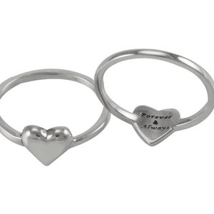 May include: Two silver rings with heart-shaped designs. One ring has a heart with the inscription "Forever & Always".