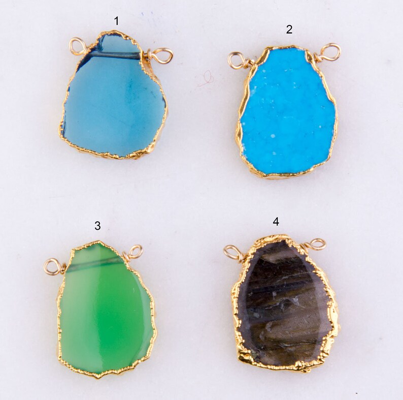May include: Four gold-rimmed agate pendants with different colors and patterns. The pendants are blue, turquoise, green, and brown. Each pendant has two gold jump rings for attaching to a necklace or bracelet.