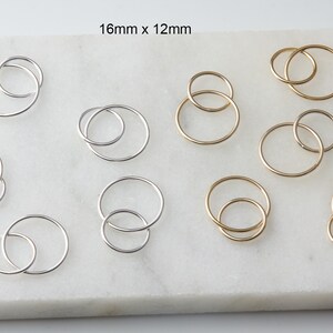 May include: Nine pairs of hoop earrings, six silver and three gold, with a smaller hoop inside a larger hoop. The earrings are 16mm x 12mm.