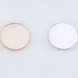 May include: Two round metal discs, one gold and one silver. The discs are smooth and have a shiny finish.