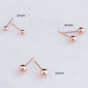 Puede incluir: Tres pares de pendientes de botón de oro rosa con bolas de diferentes tamaños. Los pendientes tienen un diámetro de 3 mm, 4 mm y 5 mm.