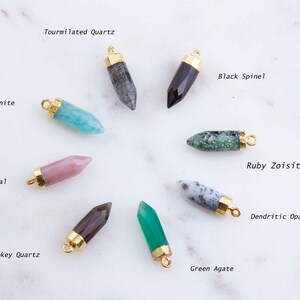 May include: Assortment of eight gemstone pendants, each with a gold-toned bail. The gemstones include: Amazonite, Pink Opal, Tourmilated Quartz, Black Spinel, Smokey Quartz, Green Agate, Ruby Zoisite, and Dendritic Opal.