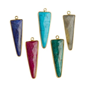 May include: Five gold-plated pendant charms with different colored gemstone inserts. The charms are shaped like a triangle with a pointed tip. The colors of the gemstones are turquoise, blue, green, gray, and pink.