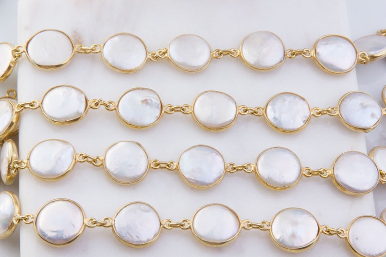May include: A strand of white pearl beads with gold accents. The pearls are round and have a smooth, polished finish. The gold accents are small and delicate, adding a touch of elegance to the strand.