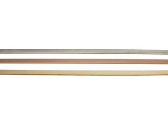 May include: Three metal strips in silver, rose gold, and gold. The strips are flat and rectangular.