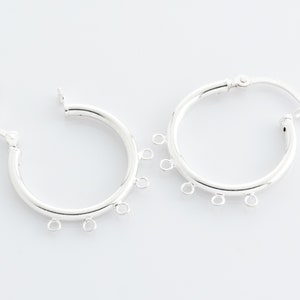 Puede incluir: Pendientes de aro de plata con cinco anillos de salto que cuelgan de la parte inferior de cada aro.