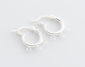 May include: Silver hoop earrings with three jump rings hanging from the bottom.