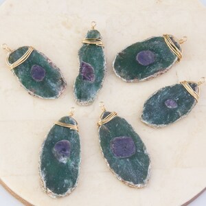 May include: Six green agate slices with purple inclusions, each wrapped with gold wire and a gold loop for hanging.