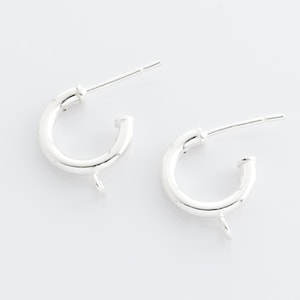 Puede incluir: Dos hallazgos de aro de pendiente de plata con un anillo de salto unido a cada aro.