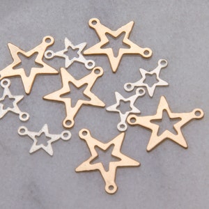 May include: A collection of gold and silver star-shaped charms with open centers. The charms have two jump rings on each, allowing them to be attached to jewelry or other crafts.