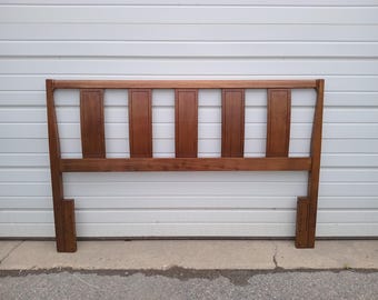 May include: A wooden headboard with a mid-century modern design. The headboard is made of dark brown wood and features vertical rectangular panels. The headboard is approximately 60 inches wide and 40 inches tall.