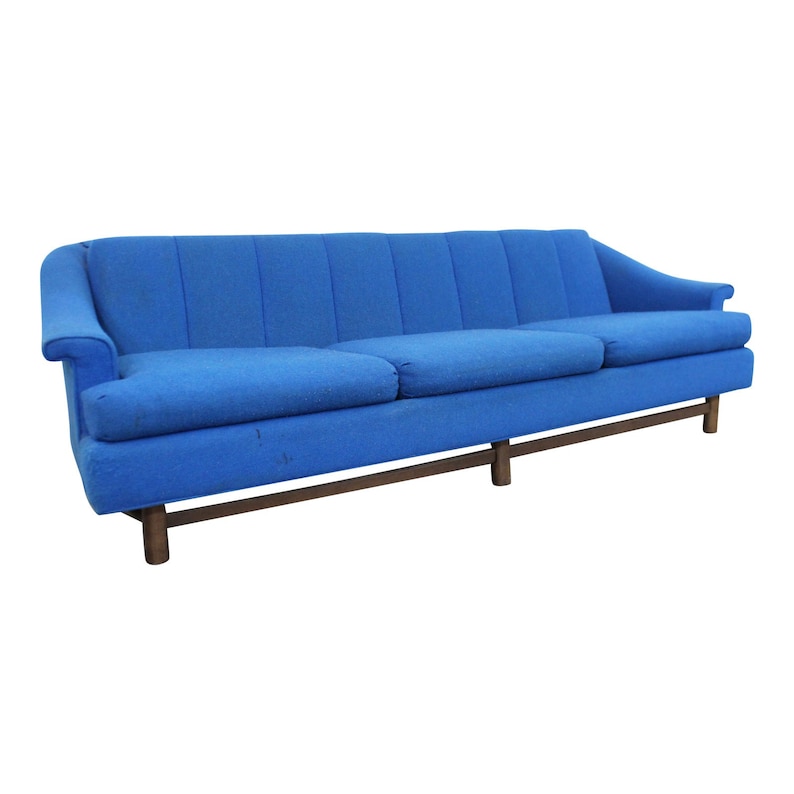 May include: A blue tufted sofa with a wooden frame and legs. The sofa has a classic mid-century modern design.