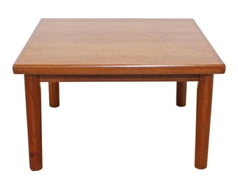 May include: A square, wooden coffee table with a light brown finish and four legs. The table is made of solid wood and has a simple, modern design.