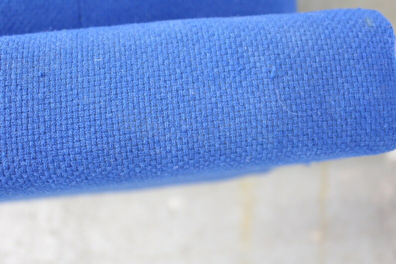 May include: Close-up of a blue fabric with a woven texture. The fabric is smooth and appears to be made of a soft material.