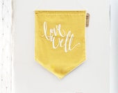 Love Well 18 by 24 Wall Hanging Pennant Banner in Mustard