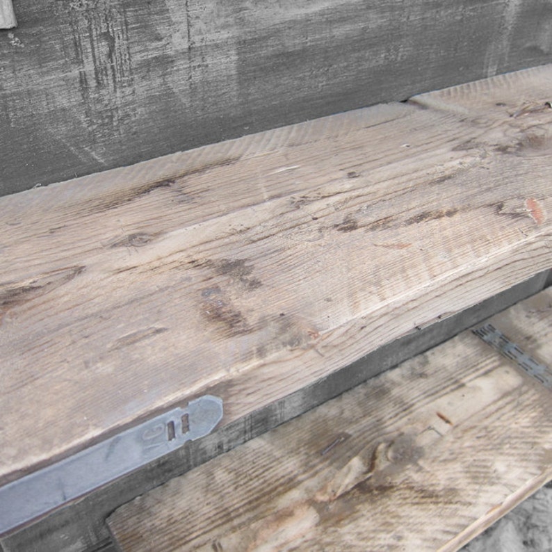 May include: A rustic wooden shelf with a metal bracket. The shelf is made of reclaimed wood and has a natural, weathered finish.