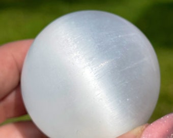 Selenite Sphere with a cats eye flash