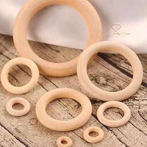 May include: Assortment of six unfinished wooden rings of varying sizes. The rings are made of natural wood and have a smooth, polished finish. They are perfect for crafting and DIY projects.