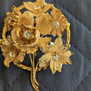 Pamper yourself today with this Vintage Gold Tone Floral Pin with Rhinestones made in Austria
