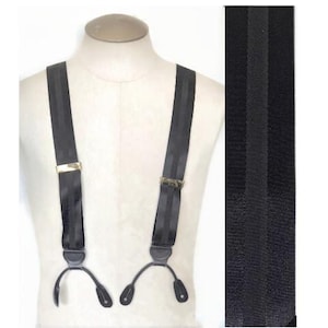 May include: Black suspenders with gold-colored metal clasps and leather button attachments. The suspenders are displayed on a mannequin. A close-up of the fabric shows a textured, striped pattern.