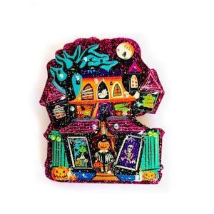 May include: A glittery pink and purple Halloween-themed house with a black tree, a full moon, and a variety of spooky characters. The house has a green fence and a variety of windows and doors.